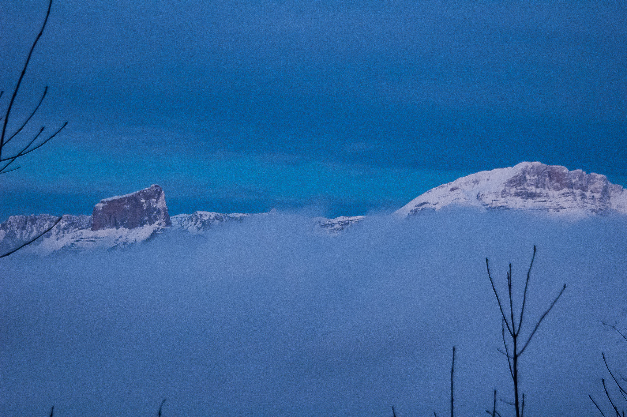 Le Mont Aiguille enneigé immergeant de la mer de nuages